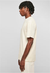 Side view of man wearing beige Urban Classics tall tee for men with short sleeves and relaxed fit