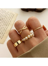 Gold rings on fingers with white pearl row and slim stacked bands