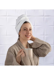 Woman wearing white towel wrapped on head and beige robe enjoying coffee representing 8 piece towel set online by Huitich