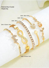 Gold crystal adjustable bracelet set with multiple cuffs, heart charms, and linked bands