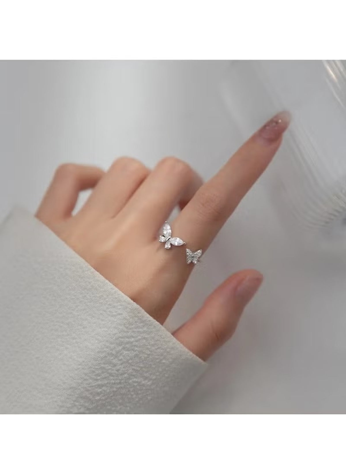 Huitich crystal butterfly ring size 6 worn on finger with white sleeve background