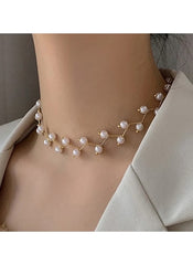 Elegant faux pearl branch necklace by Huitich worn on neck with a beige blazer