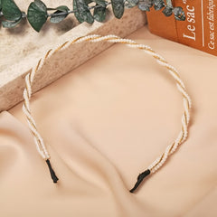 Huitich gold pearl headband for girls twisted with small pearls on a beige fabric background