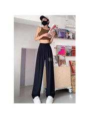 Ladies wide leg office pants black styled with a beige crop top and white sneakers by Huitich