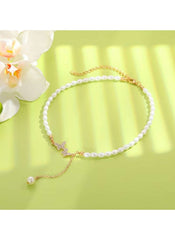 Huitich pearl butterfly necklace gold with white pearls and gold chain on green background