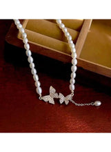 Pearl necklace with three gold butterfly charms, crystal accents, and pearl bead strand