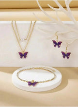 Gold-tone butterfly jewelry set with purple pendant necklace, drop earrings, and oval bracelet