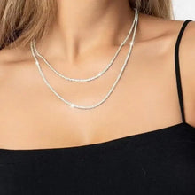 Silver layered choker necklace on neckline, double chain