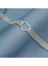 Silver rhinestone choker close-up with heart connector and adjustable chain links.