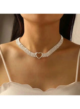 Rhinestone heart choker necklace on model’s neck, silver tone with clasp ring detail.
