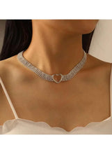 Rhinestone heart choker on model, silver sparkle band with open heart clasp at collar.