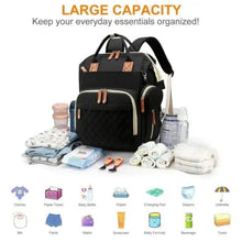 Black changing backpack with white trim, tan leather-look hardware, and front zipper pocket