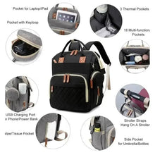 Black changing backpack with quilted front and multiple storage pockets, tan leather-look accents