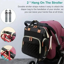 Black baby changing backpack with stroller-attachment straps and tan leather-look handles