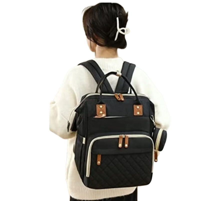 Huitich waterproof baby changing backpack in black worn by a woman for travel and convenience