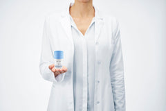 Vichy 48 hour aluminum free deodorant held by a person in a lab coat for sensitive skin protection