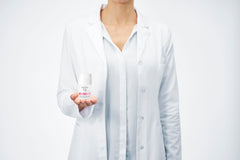 Vichy 48 hour deodorant for women held by a woman in a white lab coat, showcasing skin care expertise