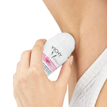 Hand holding Vichy anti-perspirant deodorant stick with pink cap