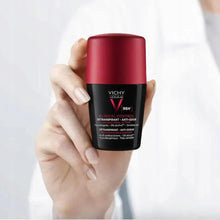 Men deodorant container with red cap and black label held in hand