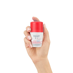 Vichy anti-stress roll-on deodorant held in a hand with a red top for effective odor protection