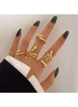 Gold-tone snake ring set with coiled designs, five rings on hand