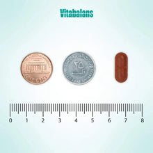 Brown oval Ferrodan Fe2+ 100 mg tablet next to coins and measuring scale