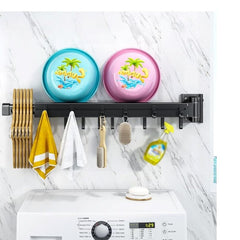 Huitich wall-mounted foldable clothes hanger rack with hangers, towels, and brushes above washing machine