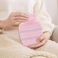 Photken mini hot water bottle with knitted cover pink zigzag pattern held by person on sofa