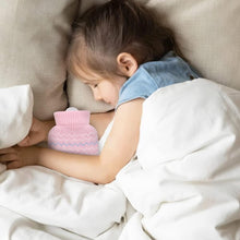 Pink knitted mini hot water bottle cover held by a child on a couch