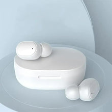 White wireless earbuds resting on open charging case
