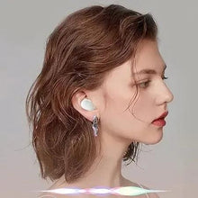 White wireless earbuds with small mic tips, worn by a woman