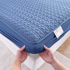 Huitich waterproof king size bedding topper in blue with quilted pattern and elastic edges being placed on mattress