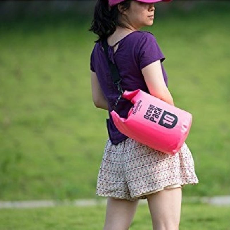 Woman wearing a pink waterproof sport shoulder bag by Huitich outdoors in casual outfit