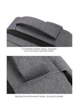 Dark grey travel backpack close-up of padded top handle and front zipper