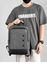 Dark grey travel backpack worn with padded shoulder straps and front zip panel