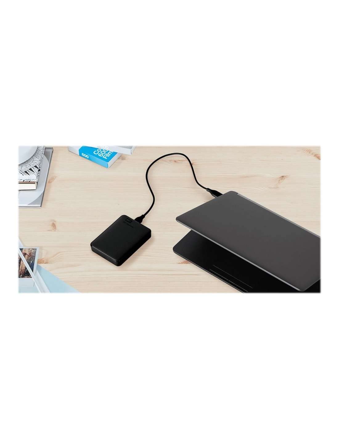 Western Digital reliable backup storage device connected to laptop on wooden desk