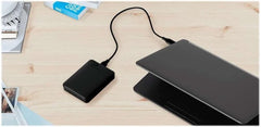 Western Digital reliable backup storage device connected to a laptop on a wooden desk