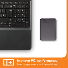 Western Digital reliable backup storage device next to laptop keyboard to improve PC performance