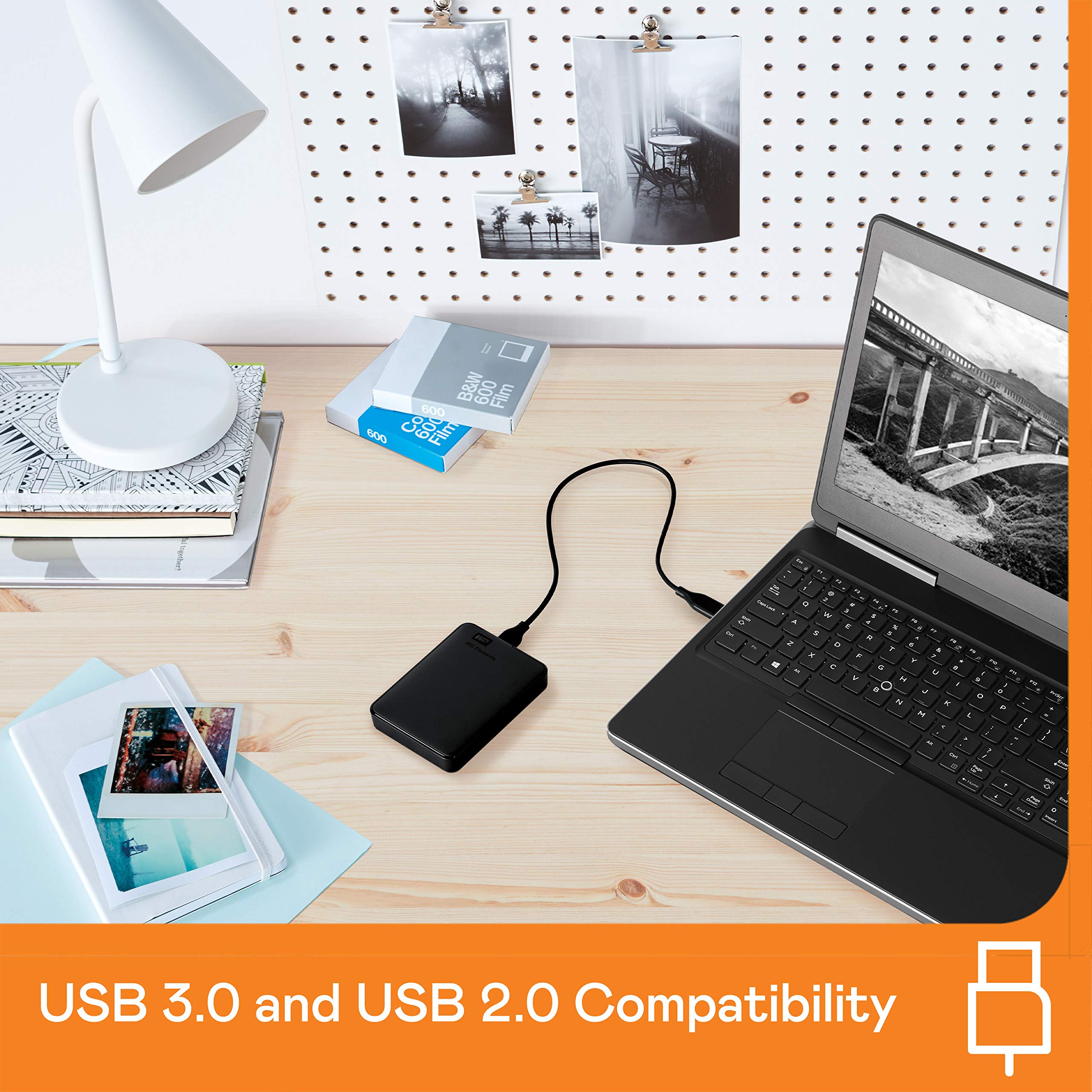 Western Digital reliable backup storage device connected to laptop on desk with photos and lamp