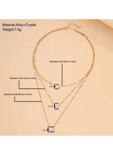 Gold three-layer charm necklace with crystal drop charms, shown with length markers