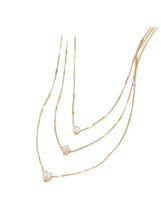 Gold three-layer charm necklace with crystal drop charms in layered curve