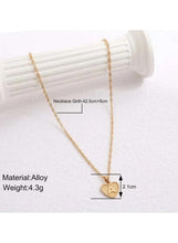 Gold heart pendant necklace with engraved A charm and delicate chain, close-up view
