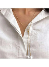 Gold lariat necklace with two white pearls hanging from long chain