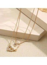 Gold-tone layered heart pendant necklace with two crystal hearts on fine chains