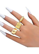 Gold-tone rings on hand: ridged open band, wide open cuff, and hammered-style band