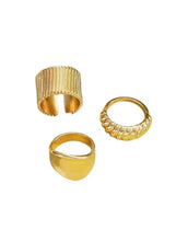 Gold-tone ring set with three irregular open bands and textured ridges, cuff style
