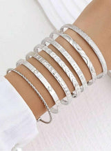 Silver-tone open cuff bangle set on wrist with beaded and rhinestone-like rows