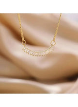 Gold tone crescent pendant necklace with small cubic stone bars