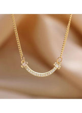 Gold curved bar crystal necklace with sparkling stones on the U-shaped bar