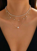 Triple-layer pearl choker necklace: three pearl strands with a central drop pearl